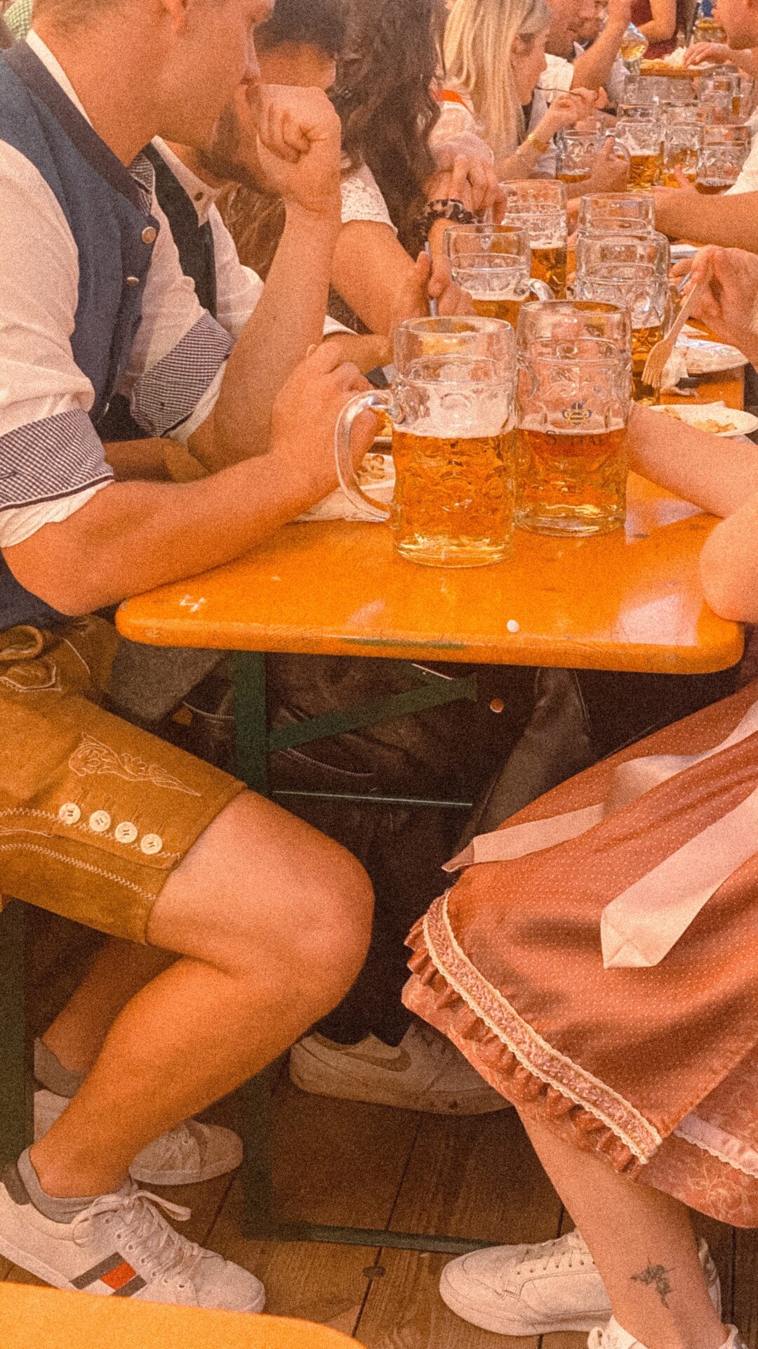 many people are sitting at the table with glasses of beer