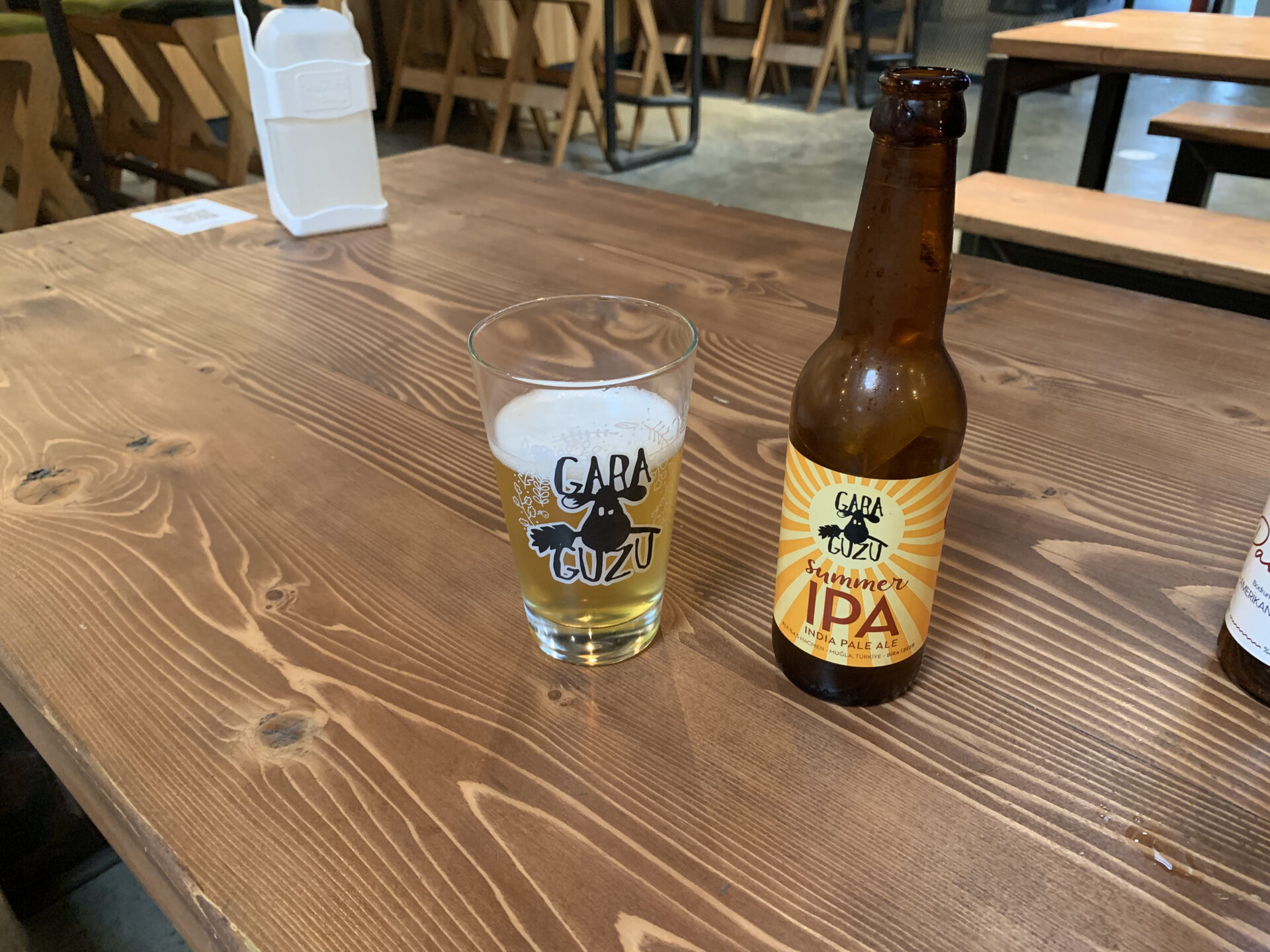 A beer glass with the inscription Gara Guzu next to a bottle of Gara Guzu IPA beer
