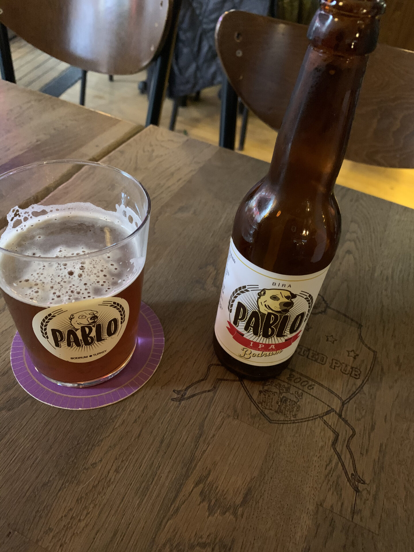 A bottle and a glass of beer from the same company, Pablo